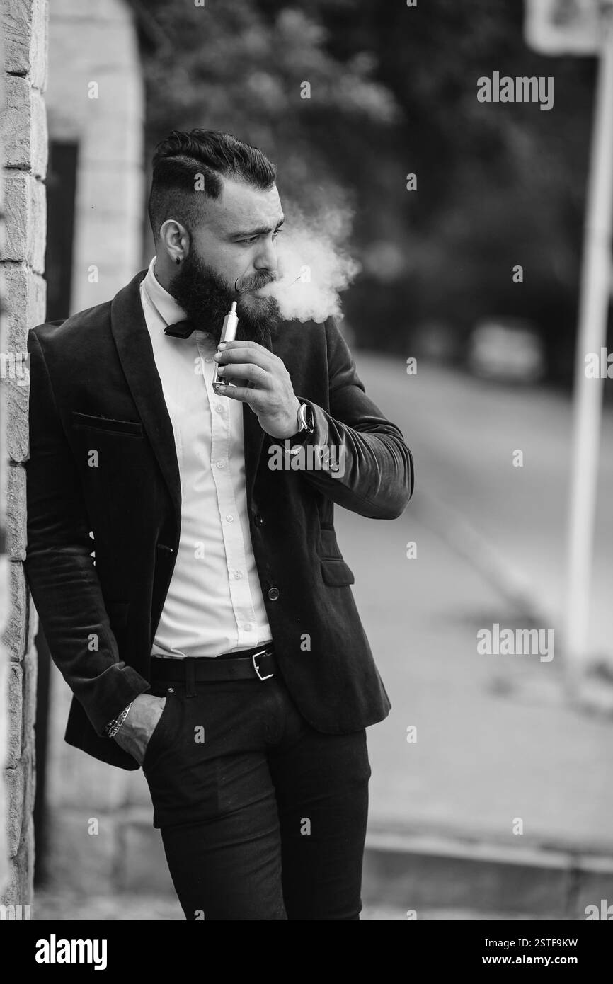 Reicher Mann in einer Jacke in der Nähe seines Hauses Stockfoto