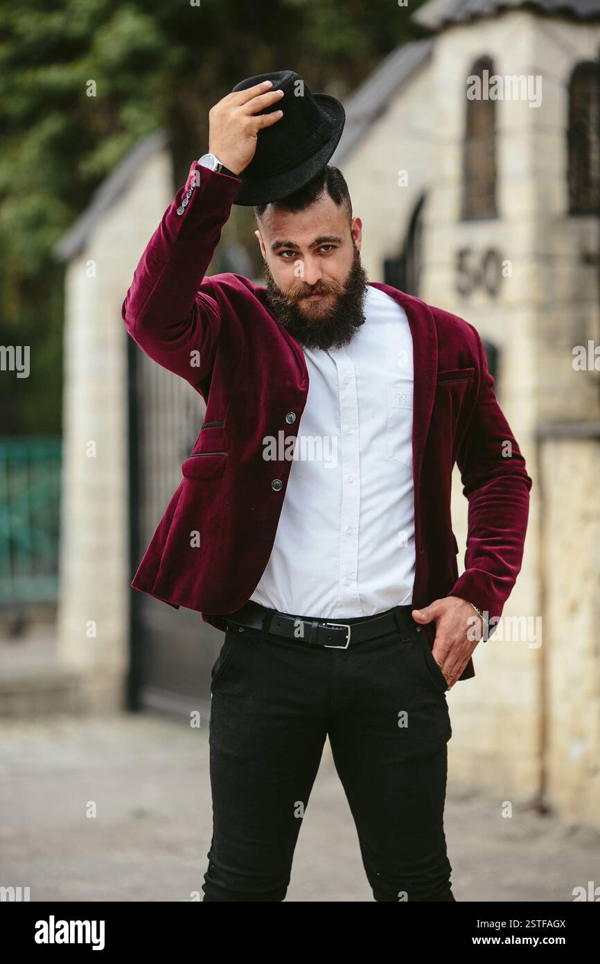 Reicher Mann in einer Jacke in der Nähe seines Hauses Stockfoto