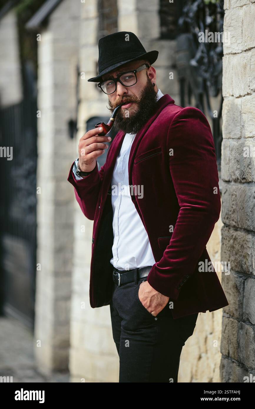 Reicher Mann in einer Jacke in der Nähe seines Hauses Stockfoto