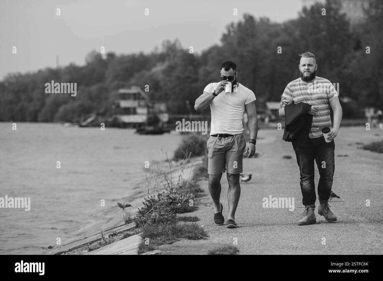 Zwei Männer gehen und Kaffee trinken Stockfoto