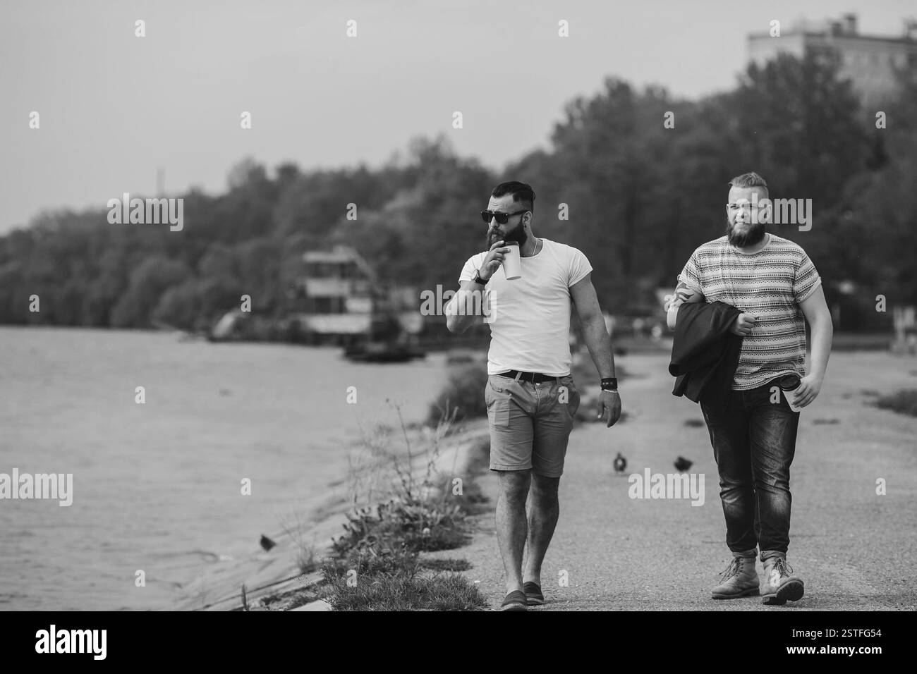 Zwei Männer gehen und Kaffee trinken Stockfoto