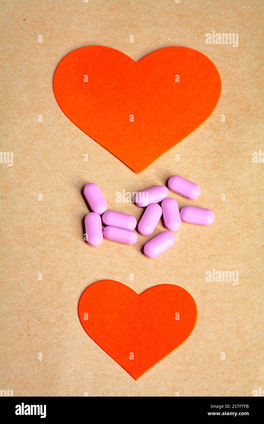 Zwei Papierherzen und Herz Pillen in der Mitte Stockfoto