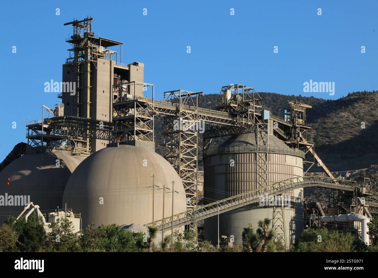 Die architektonische Gestaltung einer industriellen Zementanlage mit runden Lagerstrukturen. Stockfoto