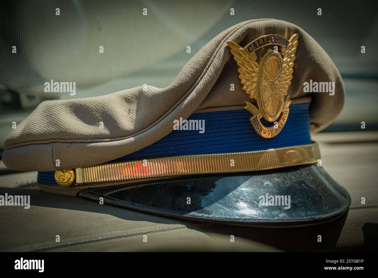 Der alte Hut im Busfahrerstil, der von den California Highway Patrolmen vor dem neueren Hut im Kampagnenstil getragen wurde. Die goldene Kappe trägt das fliegende Rad-Emblem. Stockfoto