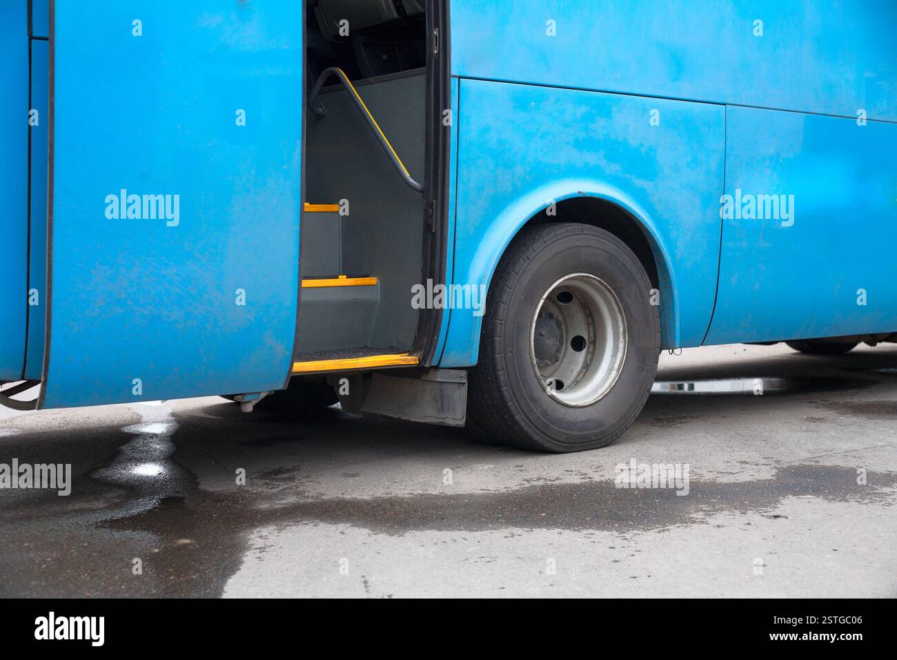 Blaue Bus an einer Station mit Tür öffnen, niemand Stockfoto