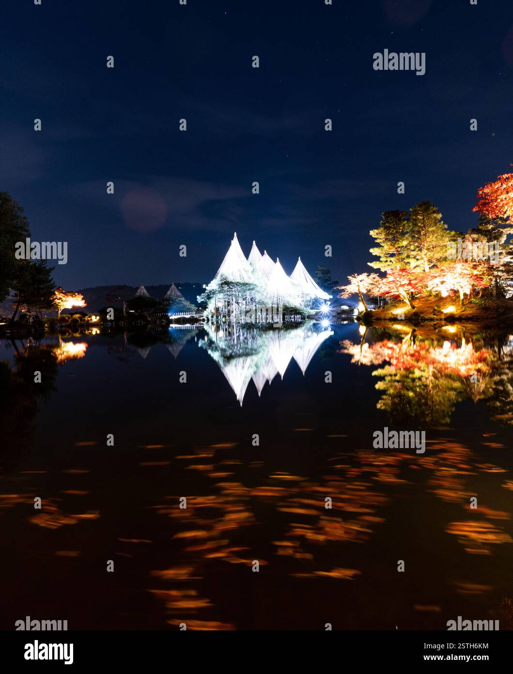 Ein ruhiger nächtlicher Blick auf den Kenrokuen Garden in Kanazawa, beleuchtet von sanften Lichtern, zeigt die Schönheit der japanischen Landschaft unter dem Nachthimmel. Stockfoto