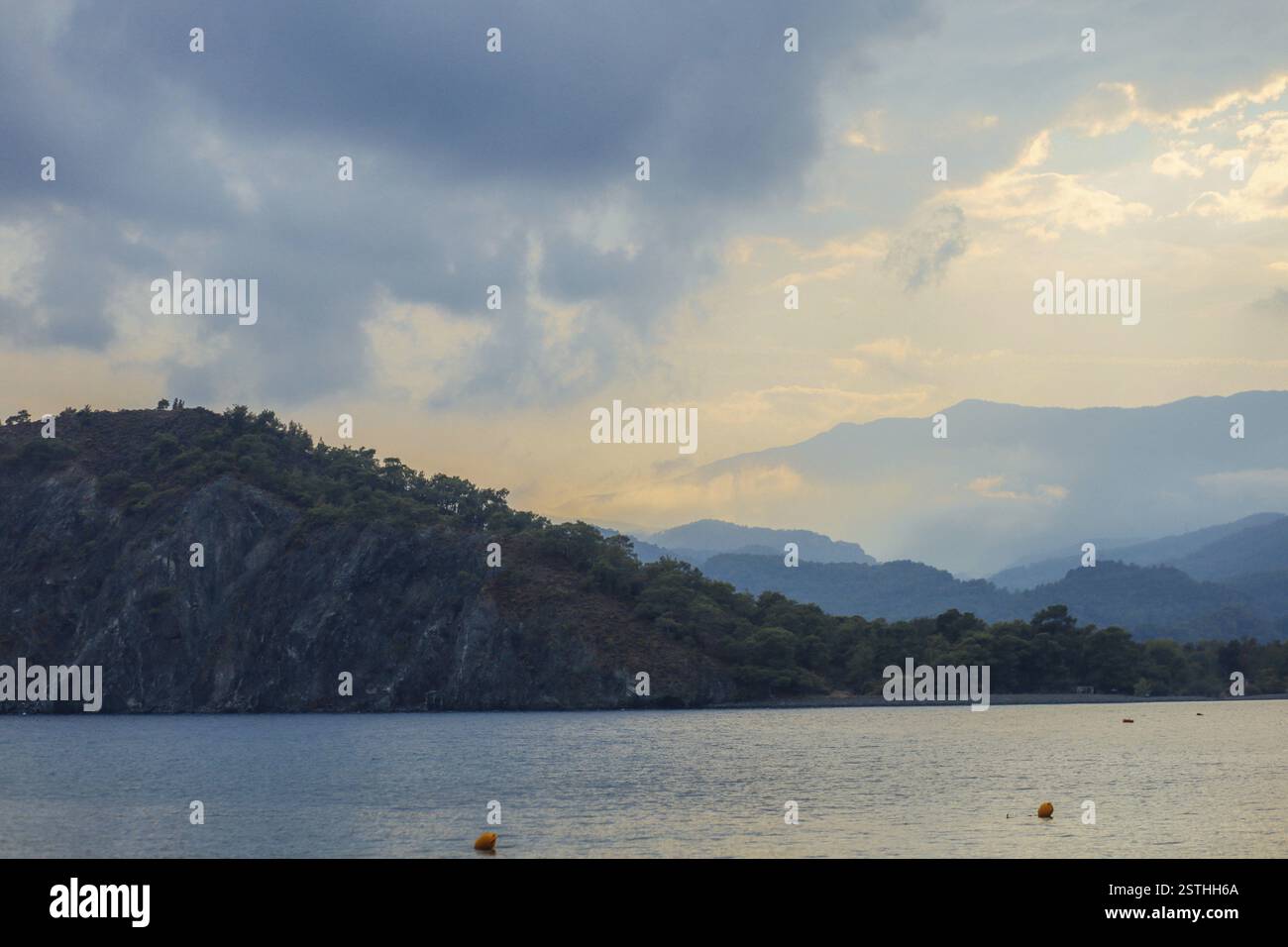Friedlicher See mit Bergen und bewölktem Himmel im frühen Morgenlicht Stockfoto