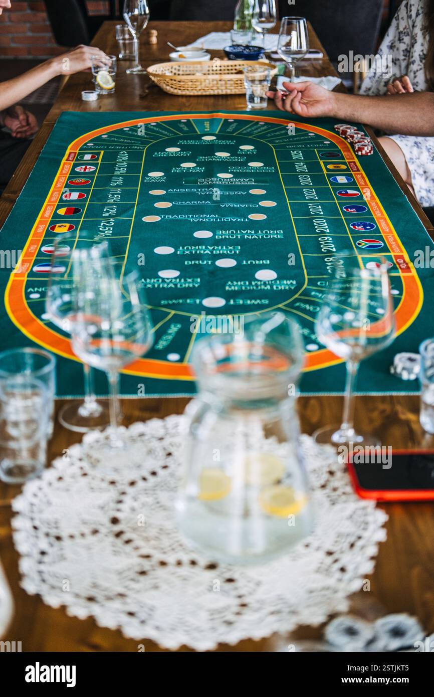Nahaufnahme leerer Weingläser auf einem Tisch mit einer Kasino-Matte im Weinstil, die Luxus und Unterhaltung verbindet Stockfoto