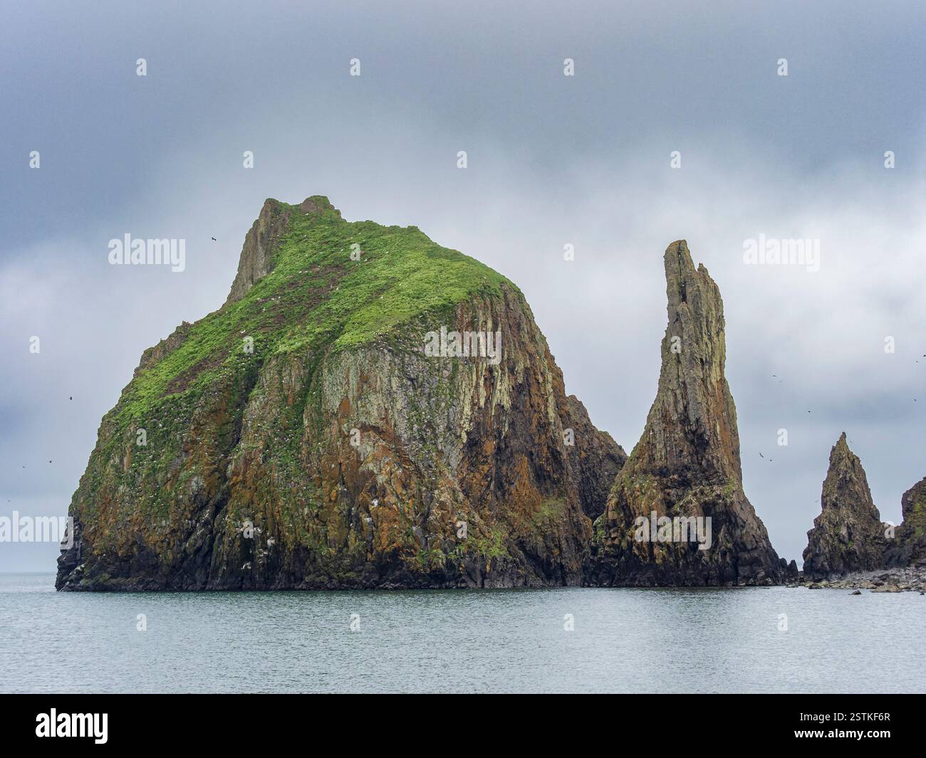 Sturmwolken über felsiger Insel und Meer Stockfoto