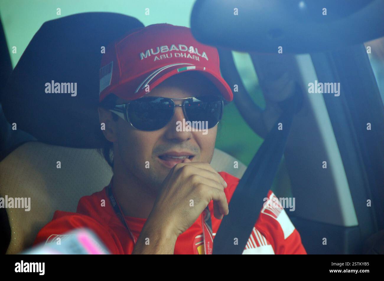 F1-Fahrer Felipe Massa in roter Ferrari-Kleidung und -Mütze, fährt seinen Straßenwagen mit angelegtem Sicherheitsgurt in Richtung Hungaroring Stockfoto