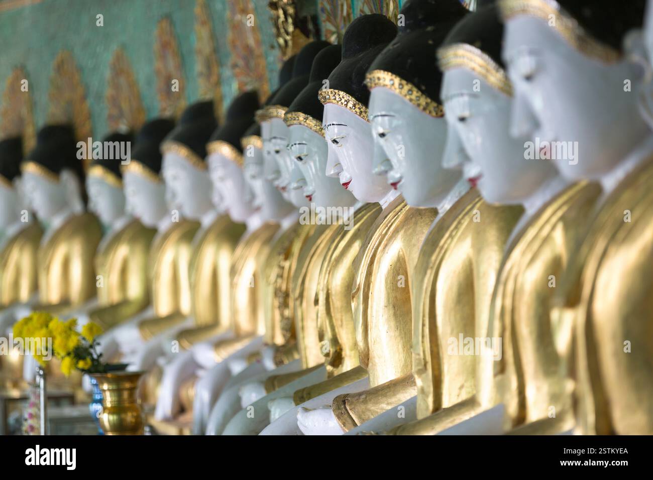 (Myanmar, Mandalay, Reihe von Buddhastatuen im Tempel. Stockfoto