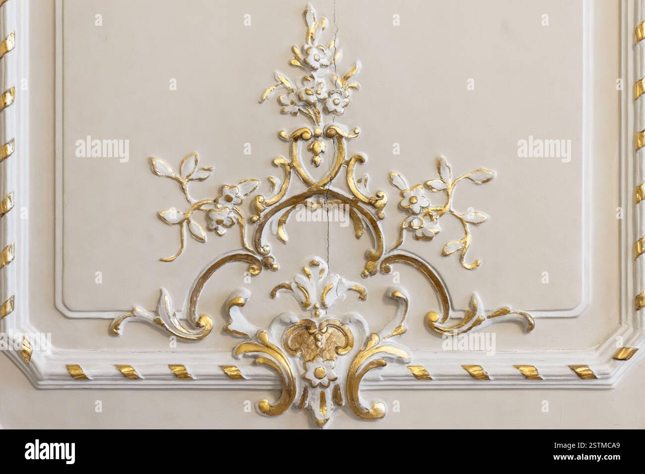 Ein detailliertes Dekorationsmotiv im Barockstil mit komplizierten Blumen- und Goldakzenten auf hellem Hintergrund. Perfekt für Themen wie Eleganz und Luxus Stockfoto