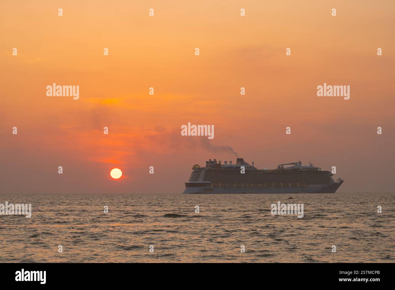 Sonnenuntergang auf einem luxuriösen Kreuzfahrtschiff verwandelt den Himmel orange und rosa und schafft eine atemberaubende Aussicht. Erleben Sie die ruhige Schönheit des Horizonts während des Tagesdurchgangs Stockfoto