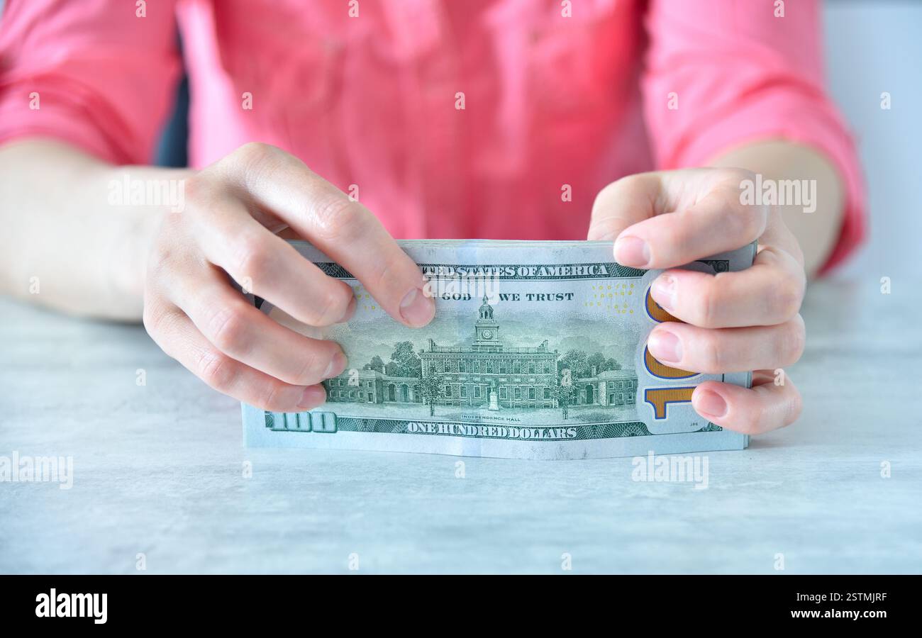 Geschäftsfrau hält US-Dollar-Bargeld im Büro. Finanzieller Erfolg und Geschäftskonzept. Nahaufnahme Stockfoto