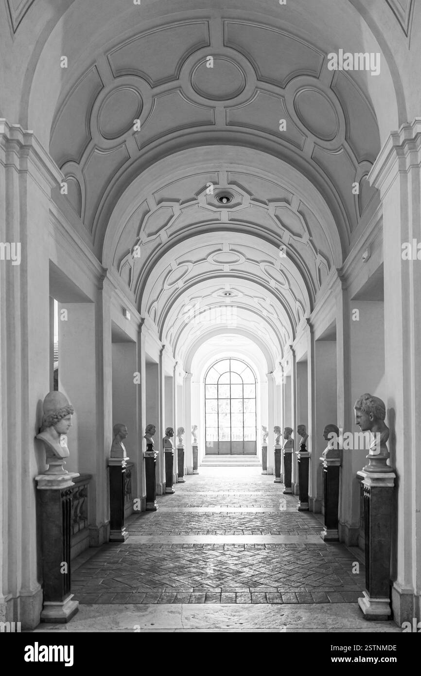 Schwarzweiß-Foto mit Halle im historischen Gebäude in Rom, dekoriert mit mehreren antiken Marmorbüsten Stockfoto