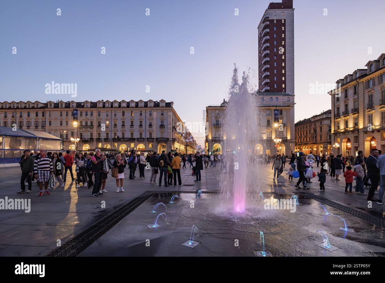 Turin, Italien. Piazza Castello bei Nacht mit Springbrunnen und Wasserspielen mit Spritzern und Farben. Torre Littoria und andere historische Gebäude illumina Stockfoto