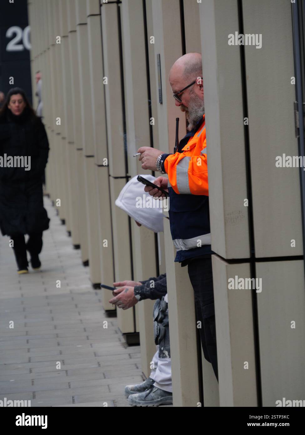 Raucher trotzen dem winterlichen Wetter und rauchen in den Pausen im Zentrum von London Zigaretten Stockfoto
