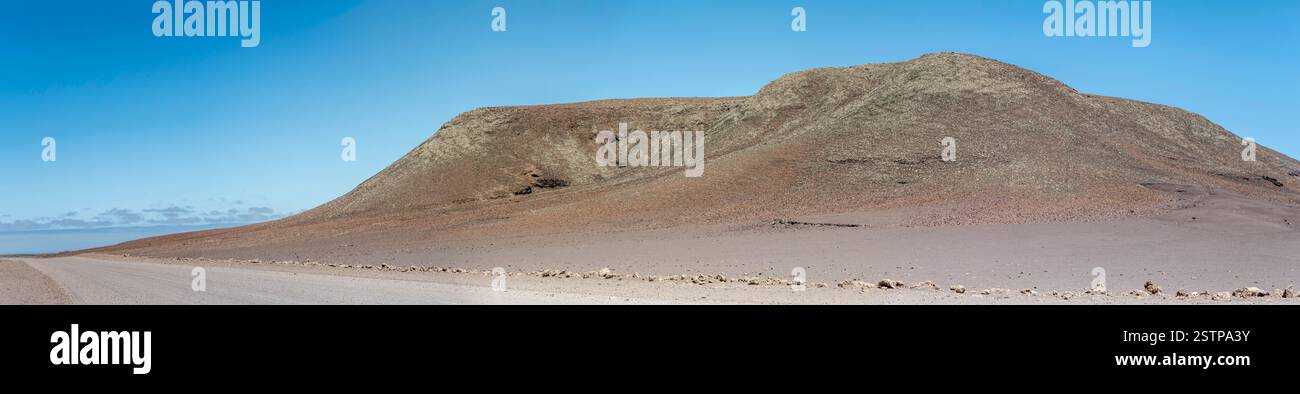 Landschaft mit Basalthügel am Vulkanplateau Etendeka und Feldweg, aufgenommen im hellen Licht des späten Frühlings in der Nähe von Springbokwasser, Namibia, Afrika Stockfoto