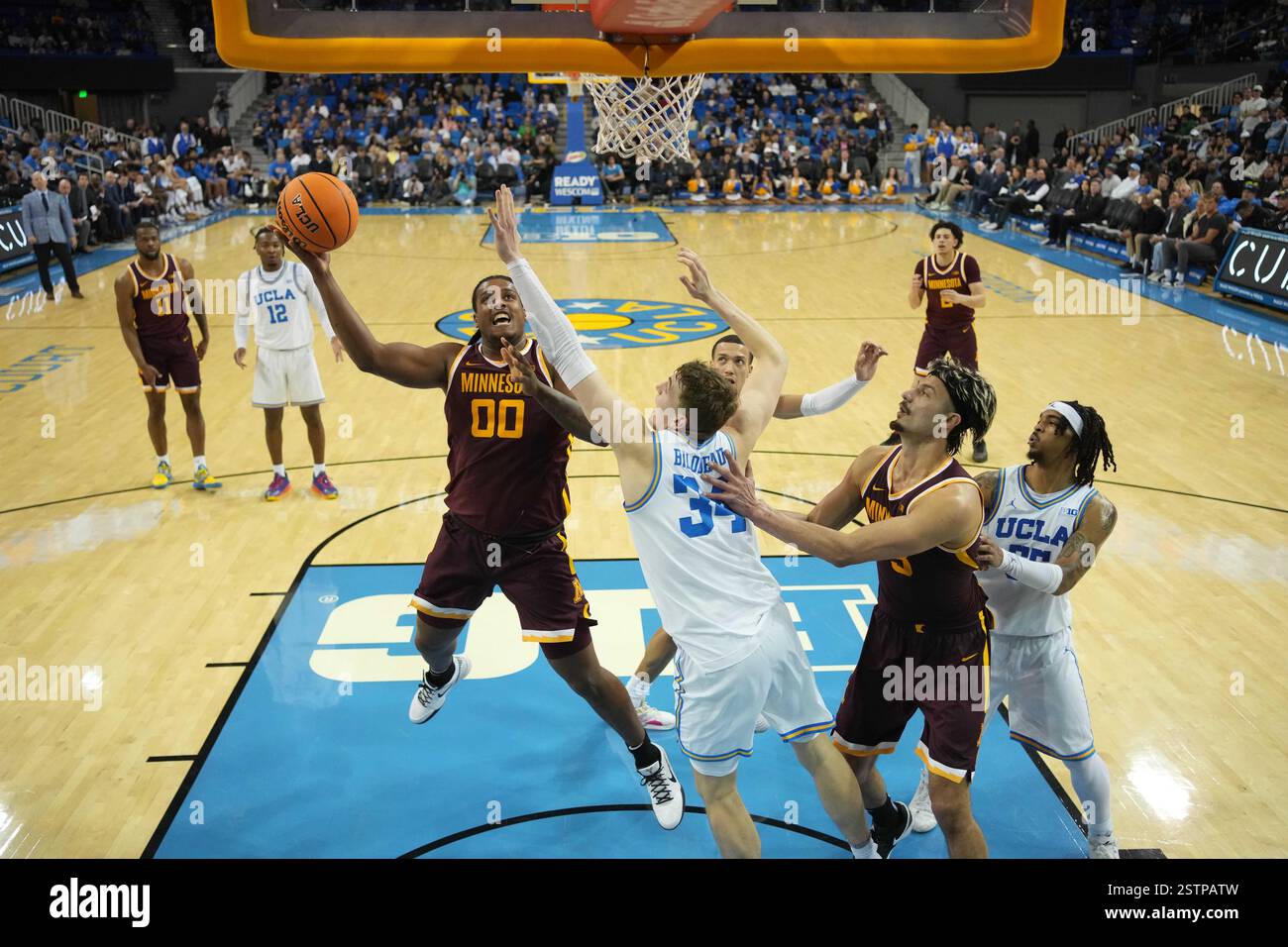 Frank Mitchell (00) schießt den Ball gegen UCLA Bruins Forward Tyler Bilodeau (34) in der ersten Halbzeit während eines Basketballspiels der NCAA College am Dienstag, den 18. Februar 2025, in Los Angeles. Stockfoto