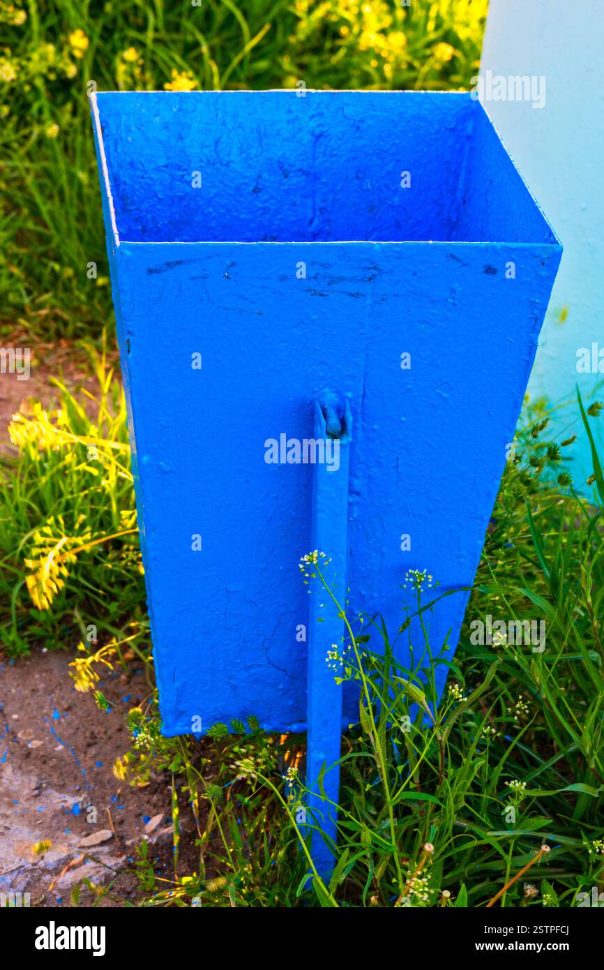 Leere Mülltonne in hellblauer Farbe im Garten Stockfoto
