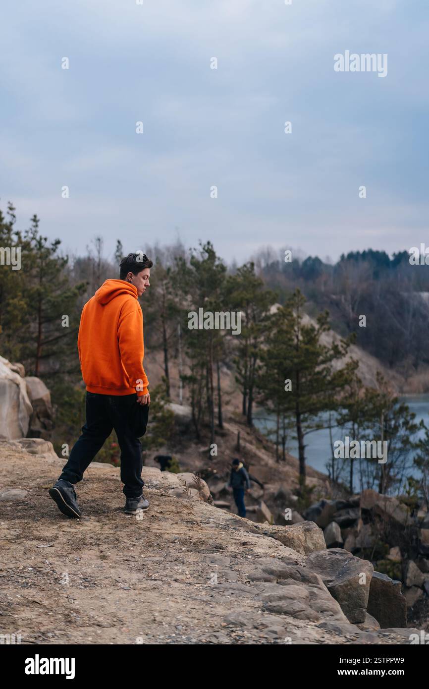 Ein junger Mann stand am Rande einer Klippe posiert für die Kamera Stockfoto
