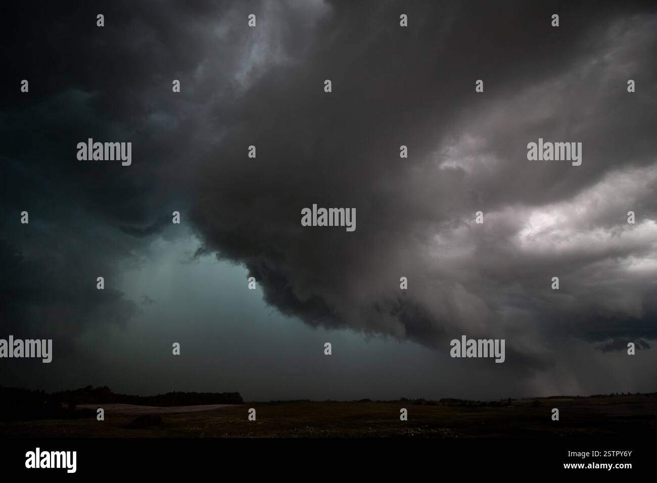 Ein mächtiges, superzelluläres Gewitter dominiert den Himmel mit unheilvollen dunklen Wolken, die über eine offene Landschaft Rollen. Stockfoto