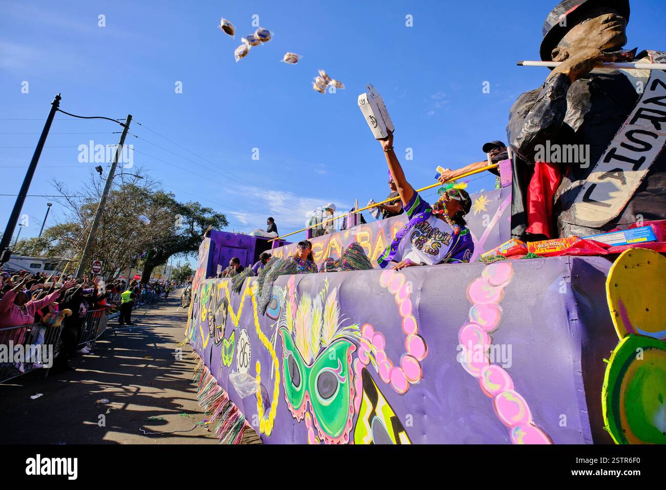 Mobile, Alabama, USA, 13. Februar 2024. 13. Februar 2024, Mobile, Alabama, USA: Masker mit der Mobile Area Mardi Gras Association wirf Moon Pies aus einem Wagen als Teil der Fat Tuesday Mardi Gras Feiern. Mobile, Alabama, ist die älteste offizielle Karnevalsfeier in den Vereinigten Staaten, die 1703 begann, als die Stadt die Hauptstadt von Französisch Louisiana war. (Kreditbild: © Dan Anderson/ZUMA Press Wire) NUR REDAKTIONELLE VERWENDUNG! Nicht für kommerzielle ZWECKE! Stockfoto