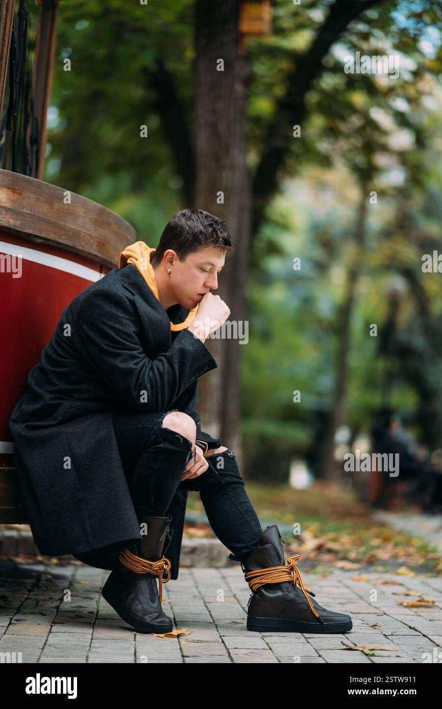 Der junge Mann in formeller Kleidung spaziert im Herbstpark. Stockfoto