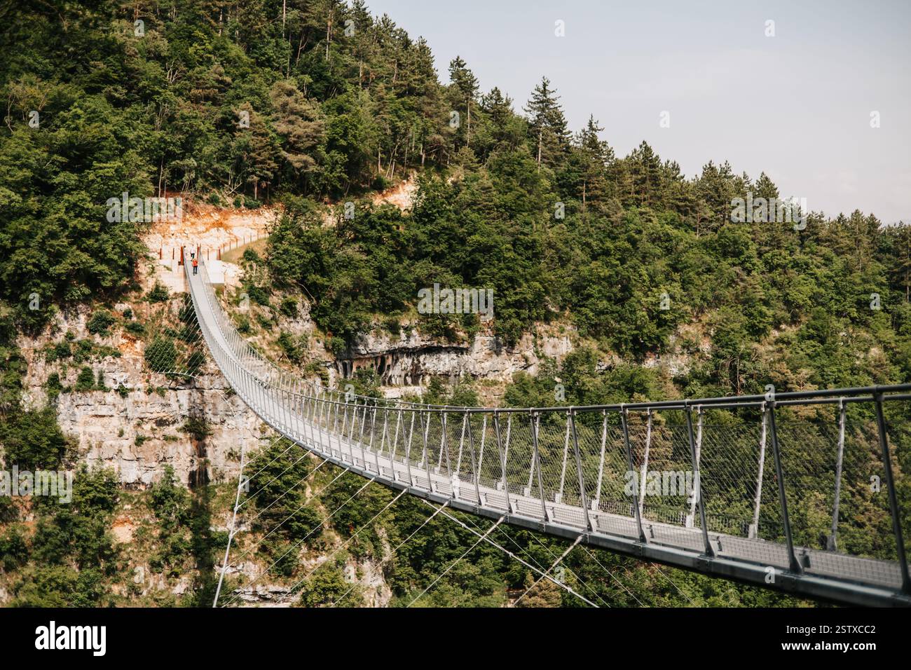 Hängebrücke zwischen Bergen. Ansicht von einer Seite aus kann die gesamte Struktur angezeigt werden. Stockfoto