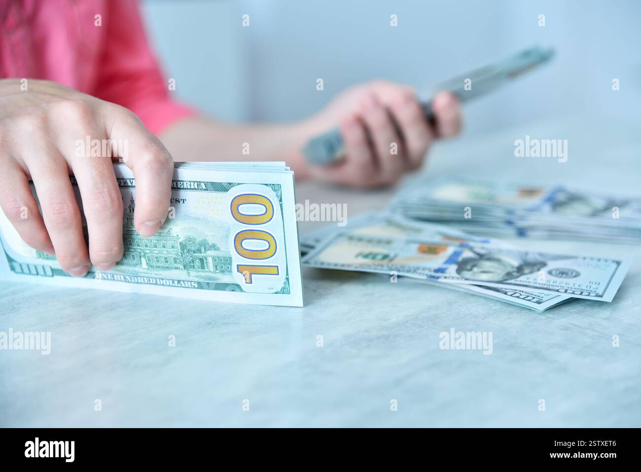 Frau, die am Tisch Dollar zählt. Finanzieller Erfolg und Geschäftskonzept. Nahaufnahme Stockfoto