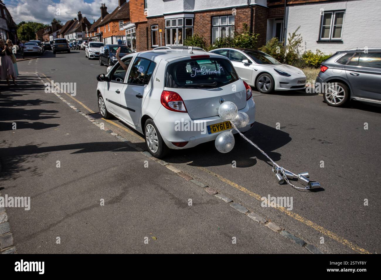 Auto, das Braut und Bräutigam in einem speziell dekorierten Auto zum Hochzeitsort bringt. Stockfoto