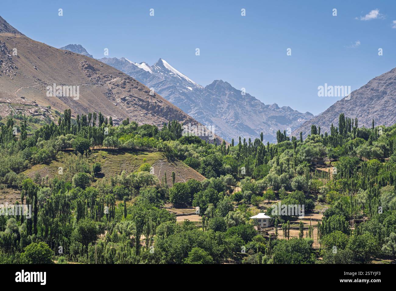 Malerischer Blick auf die Berglandschaft im Tal des Flusses Panj mit abgelegenem ländlichem Dorf auf der afghanischen Seite, Rushon, Gorno-Badakhshan, Tadschikistan Pamir Stockfoto