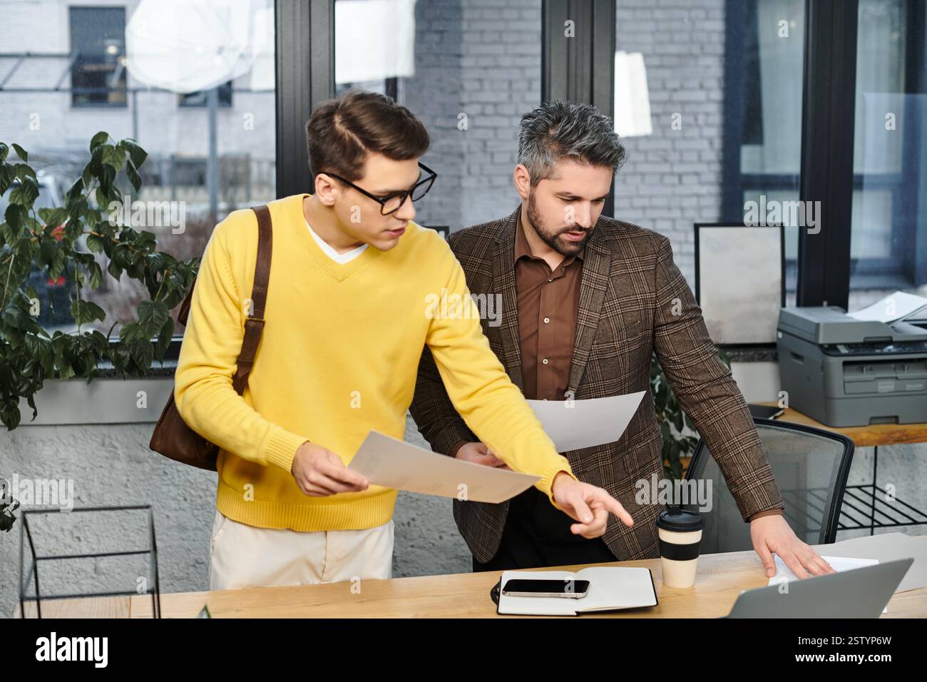 Zwei neue Mitarbeiter prüfen die Materialien zur Onboarding in einem modernen Büro am ersten Tag. Stockfoto