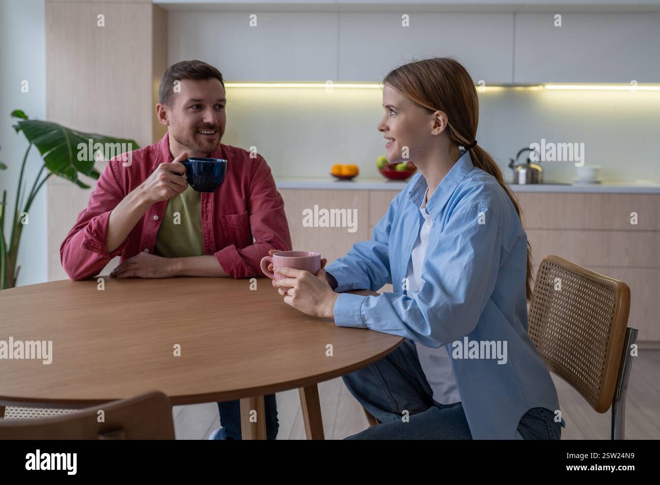 Sentimental liebende Paare verbringen gemeinsame Wochenenden zu Hause, trinken Tee, Kaffee, reden Stockfoto