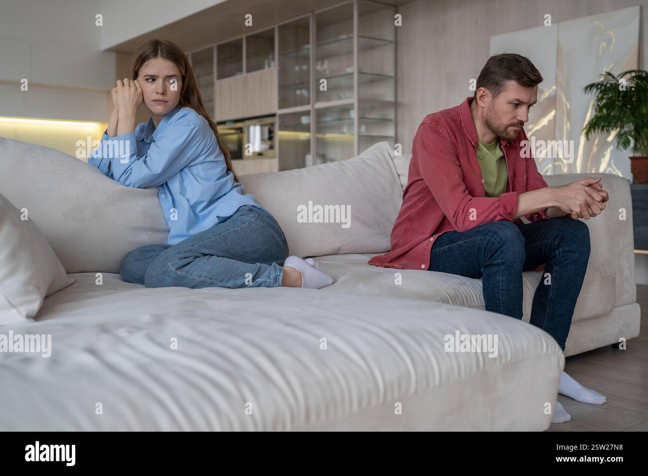 Verärgert gestritten verheiratetes Paar, das auf der Couch im Wohnzimmer sitzt und sich nach dem Kampf ignoriert Stockfoto