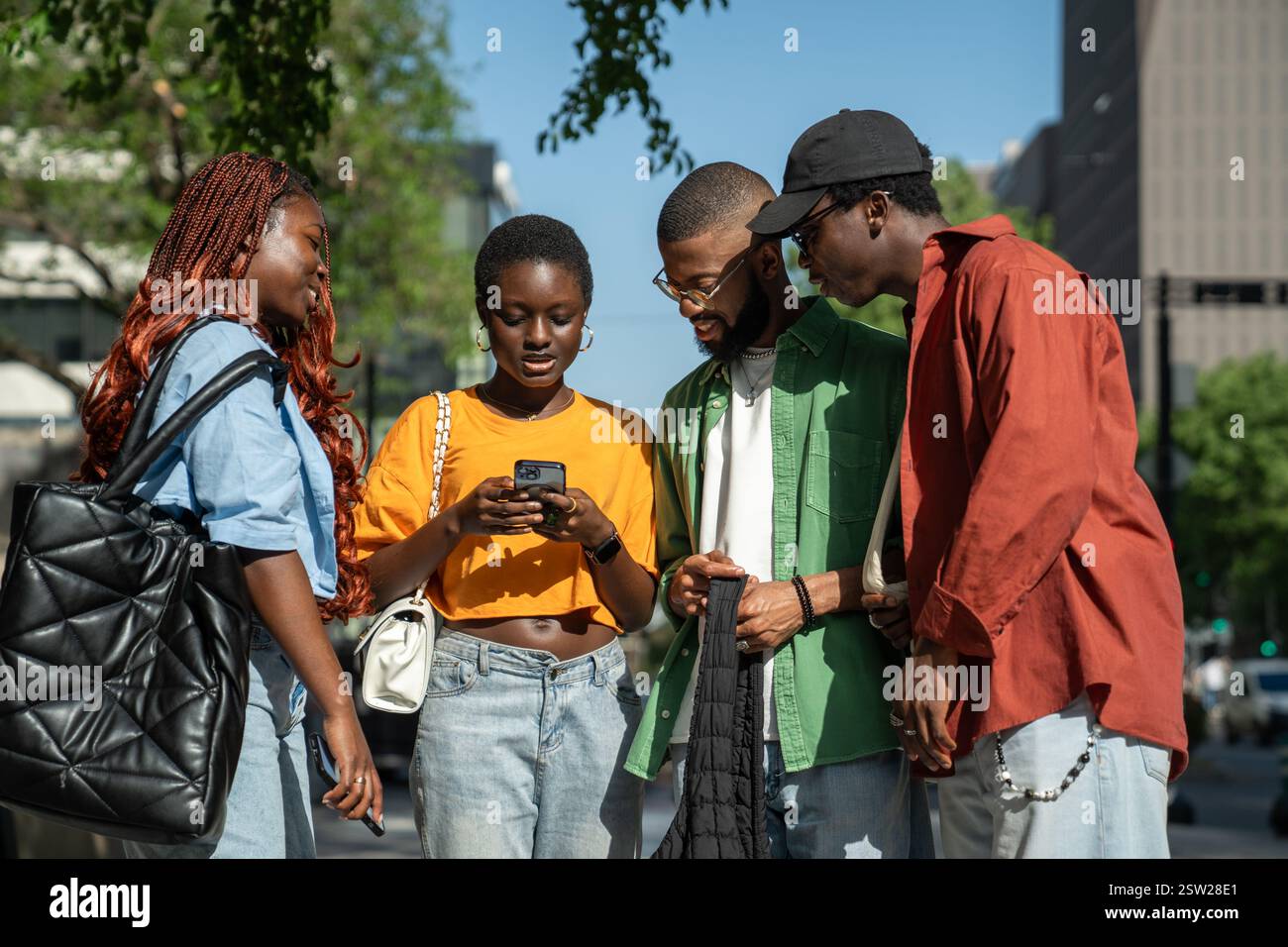 Fröhliche interessierte afroamerikanische Studenten, die nach dem Unterricht spazieren gehen und gemeinsam Freizeit verbringen. Stockfoto
