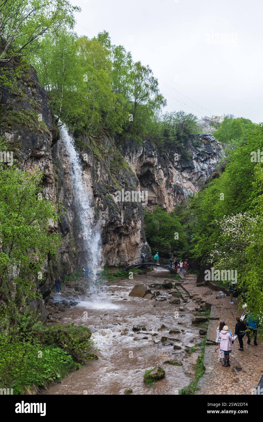 Karachay-Tscherkessia, Russland - 8. Mai 2023: Touristen besuchen Honey-Wasserfälle an den Flüssen Alikonovka und Echki-Bash. Vertikales Foto Stockfoto