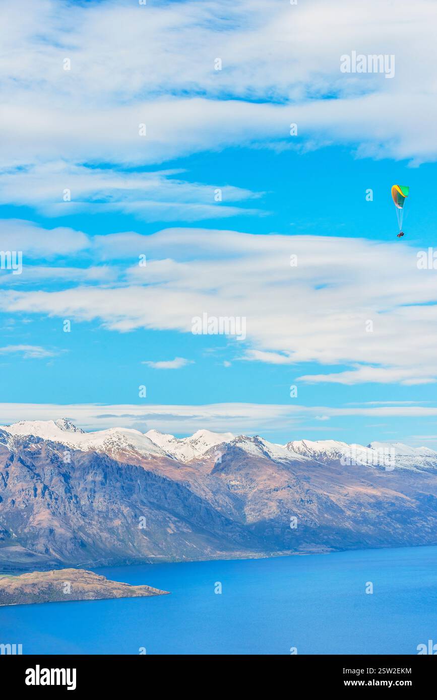 Gleitschirmfliegen über die schneebedeckten Remarkables Bergketten in Queenstown, Südinsel, Neuseeland Stockfoto