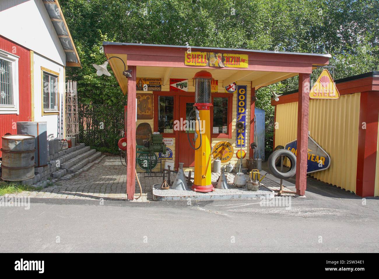 ÄLTERE TANKSTELLE in den 1930er Jahren mit gesammelten Zeitschildern und Ausrüstung Stockfoto
