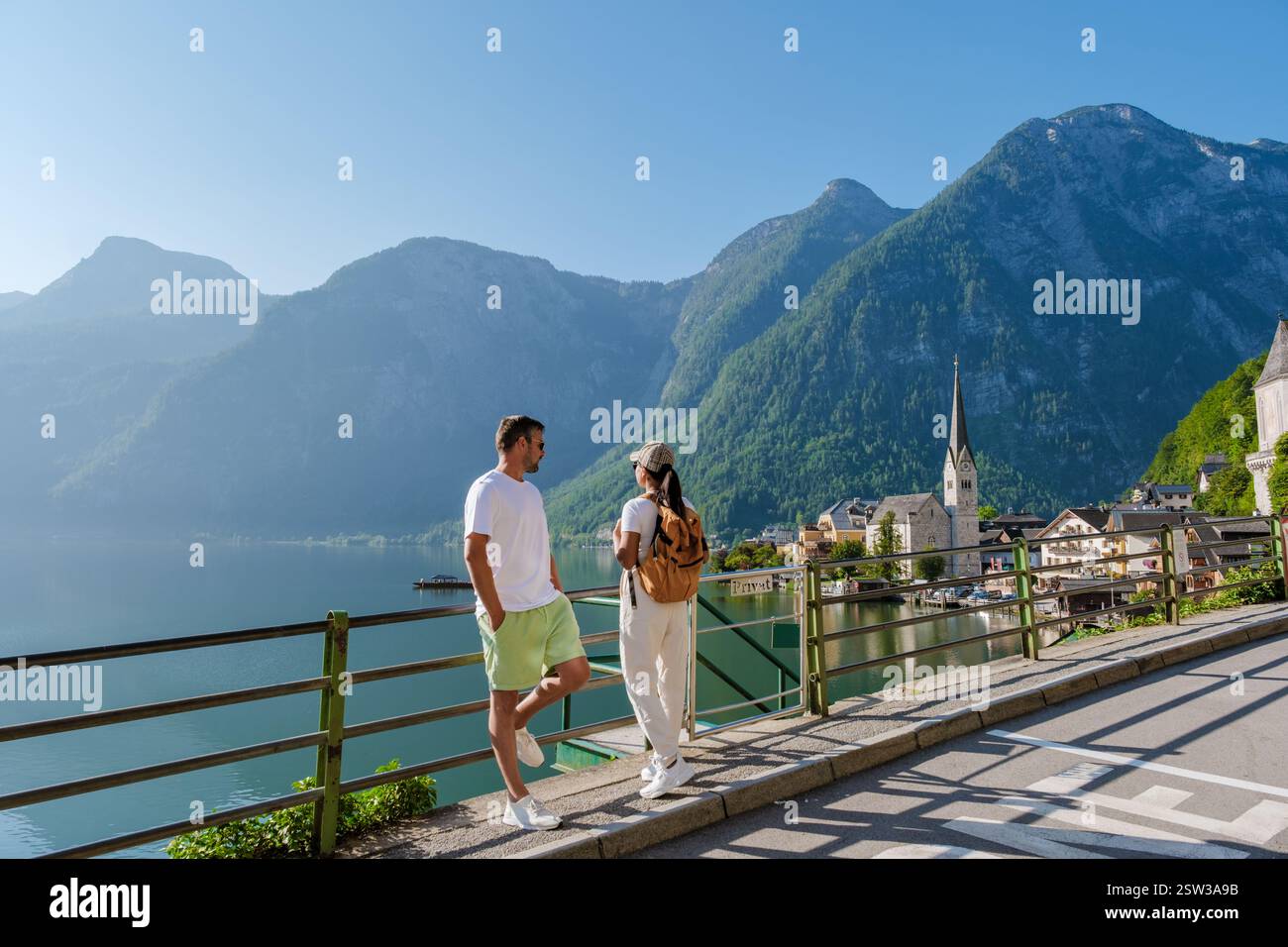 Paare genießen einen gemütlichen Spaziergang am ruhigen See in Hallstatt, Österreich an einem sonnigen Tag Stockfoto