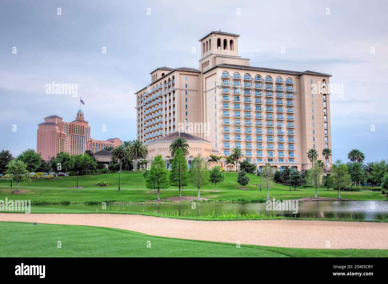 Großes Hotel mit Golfplatz davor. Das Hotel ist von Bäumen und einem Teich umgeben Stockfoto