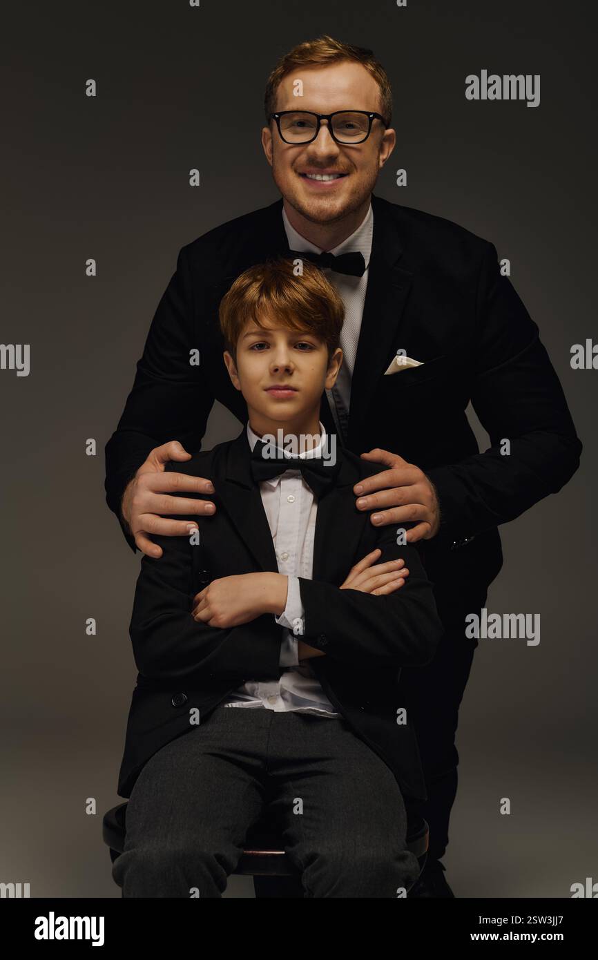 Gutaussehender Vater und Sohn in stilvollen Smoking genießen einen Moment im Studio. Stockfoto