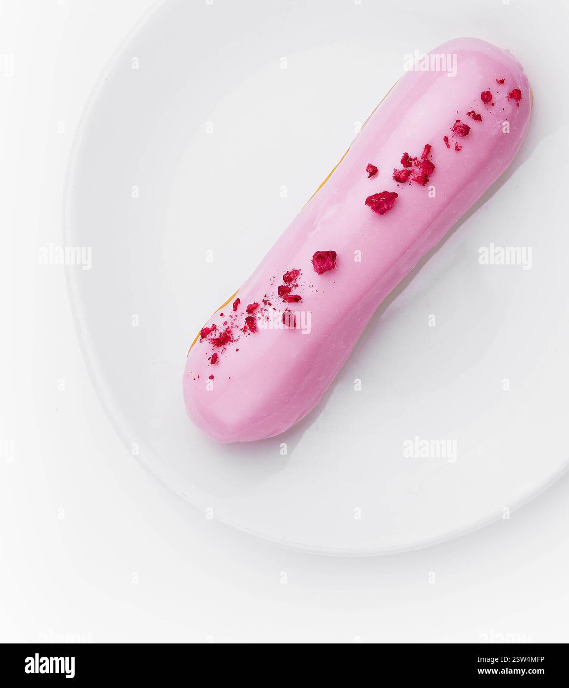 Eclair-Dessert mit rosa Glasur auf dem Teller Stockfoto