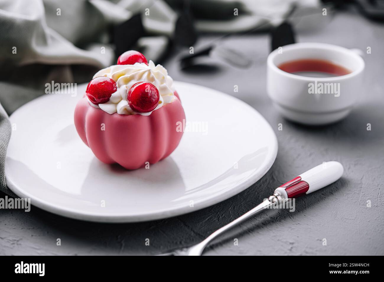 Elegantes rosafarbenes Dessert mit Beeren auf Teller Stockfoto