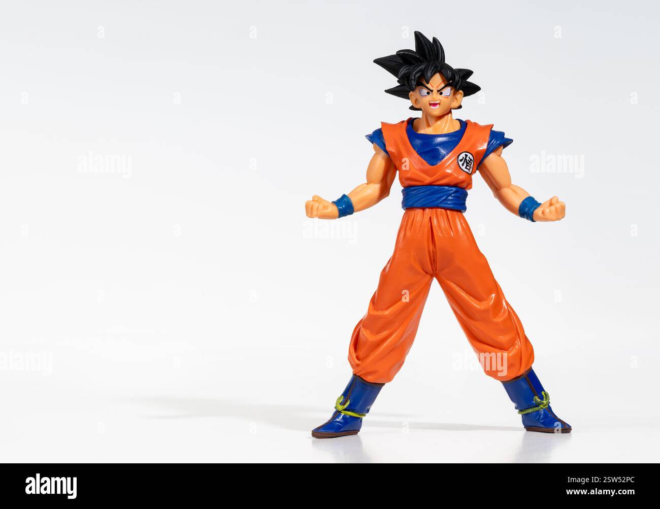 Miniatur-Figur von Goku, einem Comic-Helden von Dragon Ball, der auf weißem Hintergrund mit auseinander liegenden Beinen und geballten Fäusten steht und bereit zum Kampf ist Stockfoto