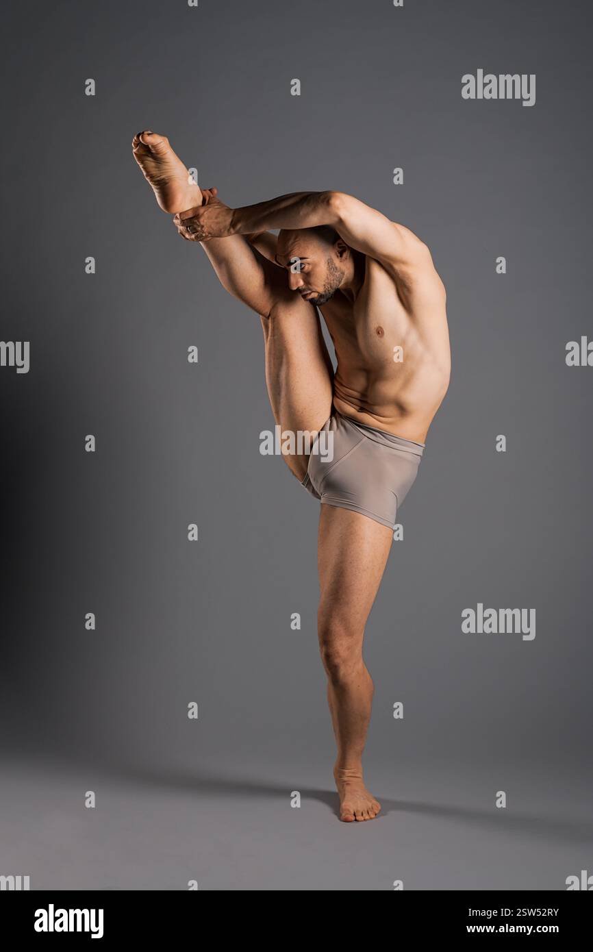 Tänzer üben eine vertikale Beinhaltung und zeigen Flexibilität und Stärke in einem Studio Stockfoto