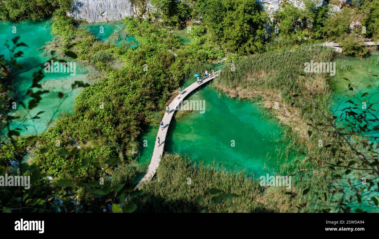 Erkunden Sie die ruhige Promenade, die sich durch die pulsierenden Plitvicer Seen in Kroatien schlängelt Stockfoto