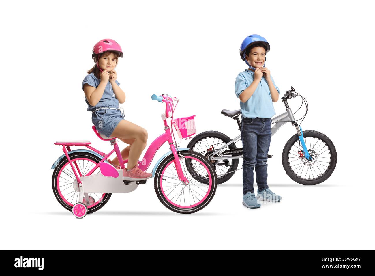 Junge und Mädchen mit Fahrrädern, die Helme auf weißem Hintergrund aufsetzen Stockfoto