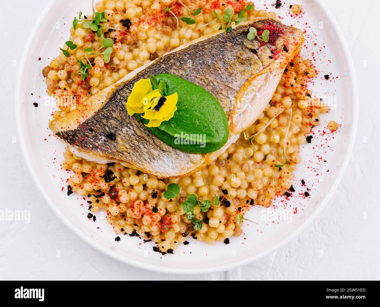 Gegrilltes Lachsfilet mit Kräuter-Couscous auf Teller Stockfoto