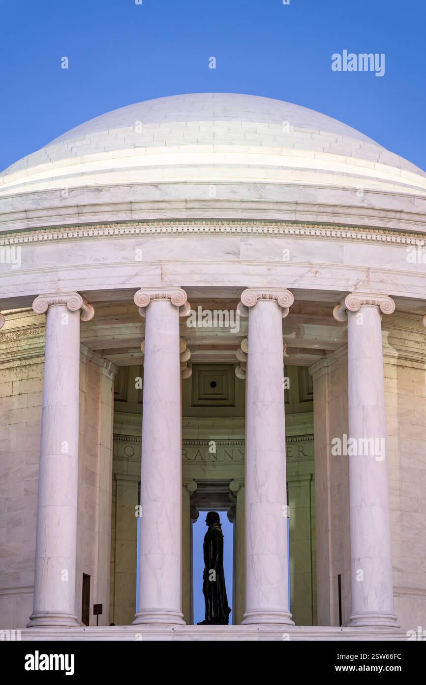 WASHINGTON DC – Ein Seitenprofil der Thomas Jefferson Statue ist durch die Säulen von der westlichen Seite des Jefferson Memorial zu sehen. Die 19 Meter hohe Bronzestatue, die von Rudulph Evans geschaffen wurde, zeigt den dritten Präsidenten Amerikas, der mit der Unabhängigkeitserklärung in der Hand steht. Das neoklassizistische Denkmal, das vom Architekten John Russell Pope entworfen wurde, bildet einen dramatischen Rahmen für die ikonische Statue. Stockfoto